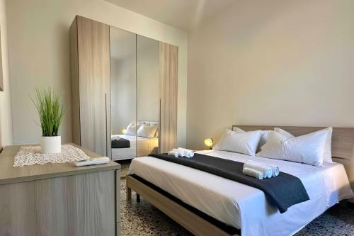 ein Schlafzimmer mit einem großen Bett und einem Spiegel in der Unterkunft La Corte Sarda Centro Storico a 5min di auto dal mare in Siniscola