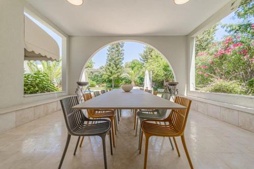- une salle à manger avec une table et des chaises en bois dans l'établissement Luxury Villa 5 BDR Pool In Caesarea, à Césarée