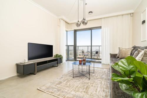 un soggiorno con una TV, un divano e un tavolo di Savyon View Tower - Isrentals a Gerusalemme