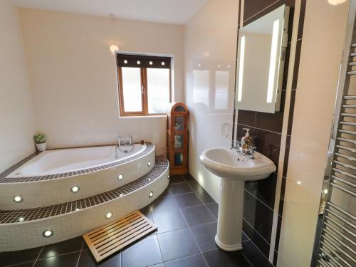 baño con bañera grande y lavamanos en House on Ring Fort Hill en Ballyhoorisky