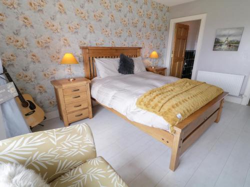 a bedroom with a bed and a chair in it at House on Ring Fort Hill in Ballyhoorisky