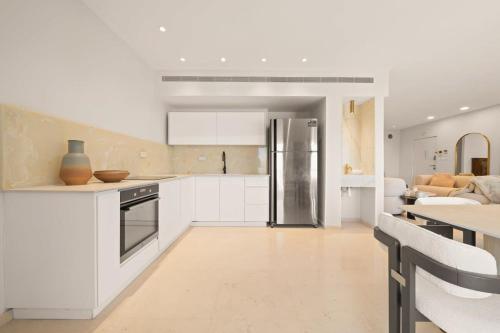 a kitchen with white cabinets and a refrigerator at King David Residence Luxury 3 BD Pool Gym Parking in Jerusalem
