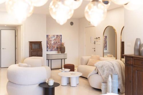 a living room with a couch and chairs and chandeliers at King David Residence Luxury 3 BD Pool Gym Parking in Jerusalem