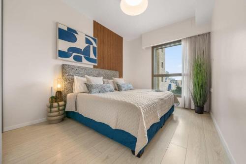 ein Schlafzimmer mit einem Bett und einem großen Fenster in der Unterkunft Luxurious 1BDR Terrace Parking in City Central in Jerusalem
