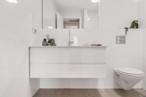ein weißes Bad mit einem WC und einem Waschbecken in der Unterkunft Luxurious 1BDR Terrace Parking in City Central in Jerusalem