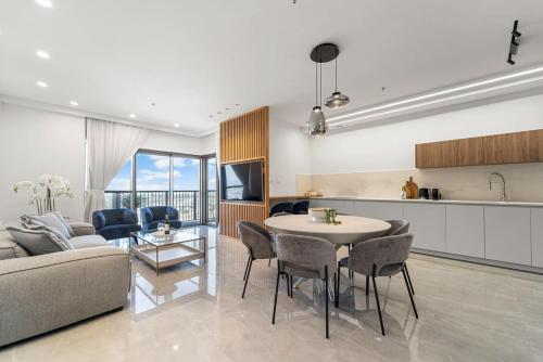 a kitchen and a living room with a table and chairs at Savyon View 3BDR - ApartHotels In City Center in Jerusalem