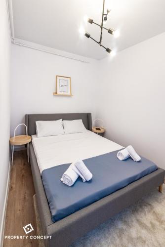 a bedroom with a bed with two towels on it at Central Residence Apartment 711 B2 in Vatra Mînăstirii Cotroceni
