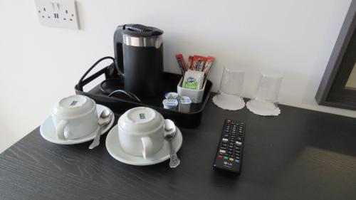 a counter with a coffee maker and a remote control at John Eoinìn's Bar and accommodation in Glencolumbkille
