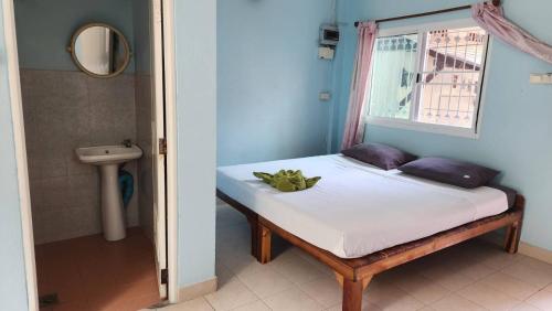 a small bed in a room with a window at Sarin Guesthouse สาริน in Koh Tao