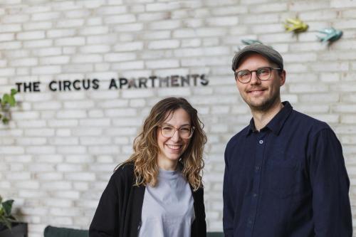 Ein Mann und eine Frau stehen vor einem Gebäude in der Unterkunft The Circus Apartments in Berlin