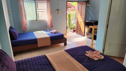 a bedroom with two beds and a mirror at Sarin Guesthouse สาริน in Ko Tao