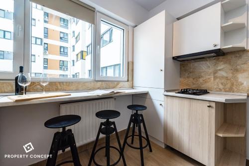 une cuisine avec trois tabourets devant un comptoir dans l'établissement Central Residence Apartment 711 B2, à Vatra Mînăstirii Cotroceni