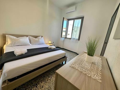 ein Schlafzimmer mit einem großen Bett und zwei Fenstern in der Unterkunft La Corte Sarda Centro Storico a 5min di auto dal mare in Siniscola