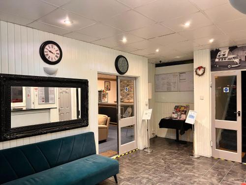 a room with a couch and clocks on the wall at The oxford Hotel in Blackpool