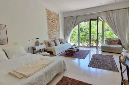 1 dormitorio con 1 cama grande y sala de estar en Cosy Studio in Mamilla, free parking up to 5 ppl, en Jerusalén