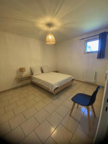 - une chambre avec un lit, une chaise et un lustre dans l'établissement Spacieux 2 chambres, CLIM, parking prive ferme, LOCAL VELOS, à Entraigues-sur-la-Sorgue