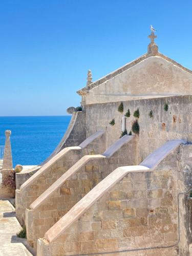a set of stairs with the ocean in the background at Innesto Rooms - Monopoli in Monopoli