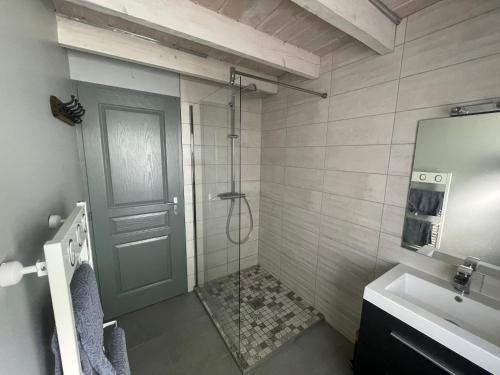 une salle de bain avec une douche avec une porte vitrée dans l'établissement Le Chalet de Juliette, à Gérardmer