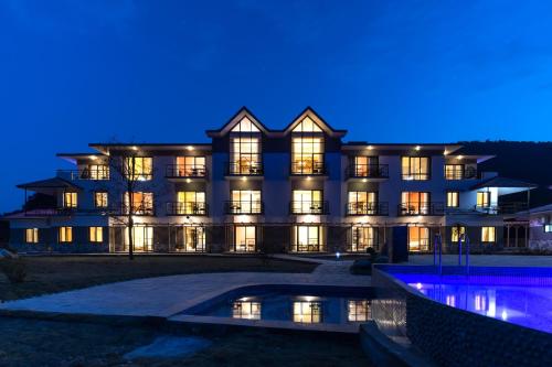 a building with a pool in front of it at night at Sunshine Resort Pokhara in Pokhara