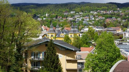 a city viewed from a hill with houses at High End Velden am Wörthersee in Velden am Wörthersee