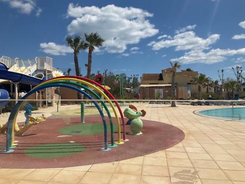 une aire de jeux dans un complexe hôtelier avec des montagnes russes dans l'établissement camping siblu sable du midi, à Sérignan
