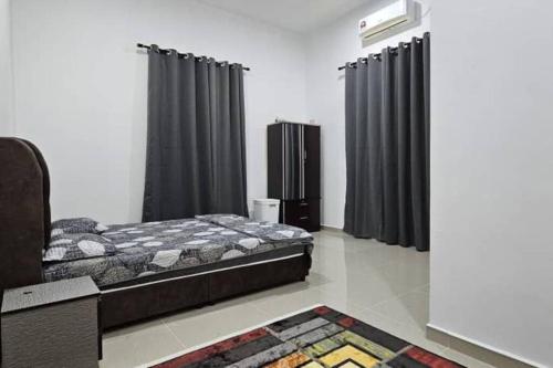 Schlafzimmer mit einem Bett und schwarzen Vorhängen in der Unterkunft Qis Homestay 3 Rooms in Kampong Nibong