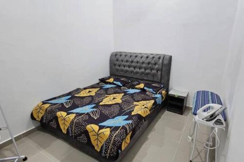 Bett mit Daunendecke und Telefon in einem Zimmer in der Unterkunft Qis Homestay 3 Rooms in Kampong Nibong