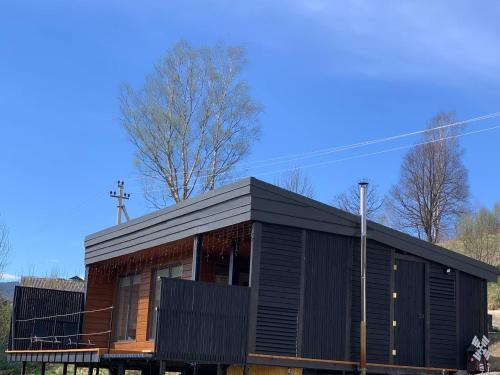 a black house with a black roof at Ecottage котедж для двох у горах із чаном-джакузі in Slavske