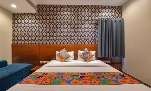 a bedroom with a bed and a blue couch at FabHotel The Wind Palace in Jaipur
