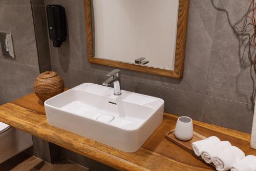 a bathroom with a white sink and a mirror at Utopia Luxury Suites - Old Town in Rhodes Town