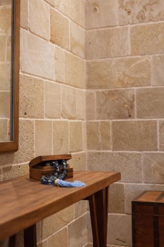 a wooden table in front of a brick wall at Utopia Luxury Suites - Old Town in Rhodes Town