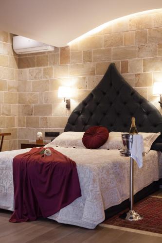 a bedroom with a large bed with a large headboard at Utopia Luxury Suites - Old Town in Rhodes Town