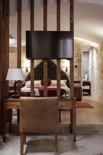 a bedroom with a bed and a desk with a chair at Utopia Luxury Suites - Old Town in Rhodes Town