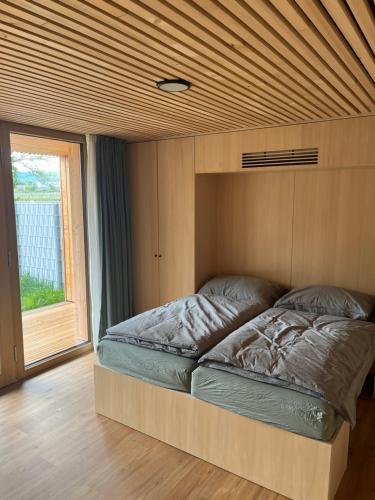 Bett in einem Zimmer mit Holzdecke in der Unterkunft Tiny House Brunn am Gebirge in Brunn am Gebirge