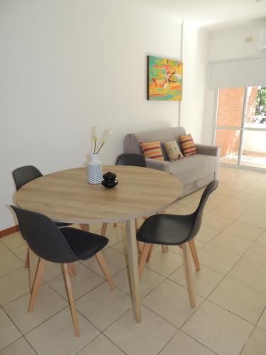 a table and chairs in a living room with a couch at Tu alquiler Resistencia in Resistencia