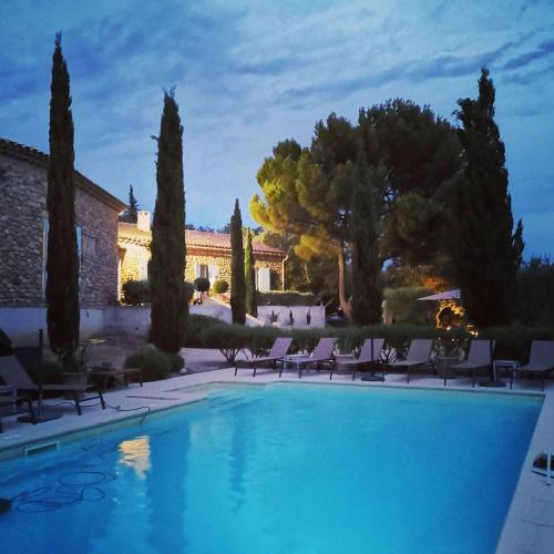 une piscine en face d'une maison avec des chaises et des arbres dans l'établissement LA FONTAINE AU LOUP, à Saint-Maurice-sur-Eygues