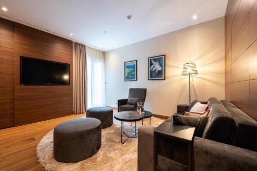 a living room with a couch and a tv at Hotel De‘Andros Virpazar in Virpazar