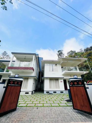 a white building with two doors in front of it at DREAM NEST POOL VILLAS in Wayanad