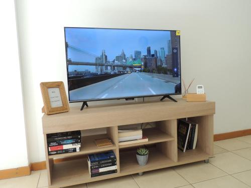 a flat screen tv sitting on a wooden entertainment center at Temporario en Resistencia con cochera in Resistencia