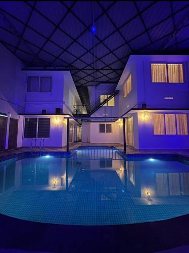 a large swimming pool in a building at night at DREAM NEST POOL VILLAS in Wayanad