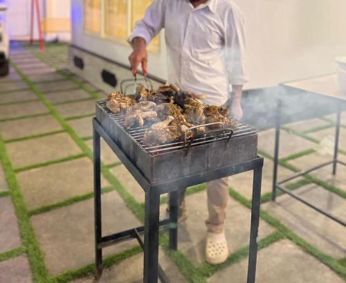 a man is cooking food on a grill at DREAM NEST POOL VILLAS in Wayanad