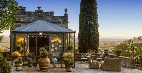 a gazebo in a garden with chairs and trees at Il Falconiere Relais & Spa in Cortona