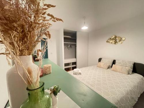 une chambre avec un lit et un vase avec des plantes dans l'établissement La Balneaire maison de standing tout confort, à Boisseuil