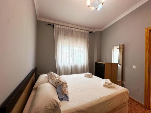 une chambre avec un lit et une fenêtre dans l'établissement BAJBAJ - Apartamento 2 dormitorios a 100 metros de la Playa del Bajondillo, a 300 metros del centro de Torremolinos, à Torremolinos