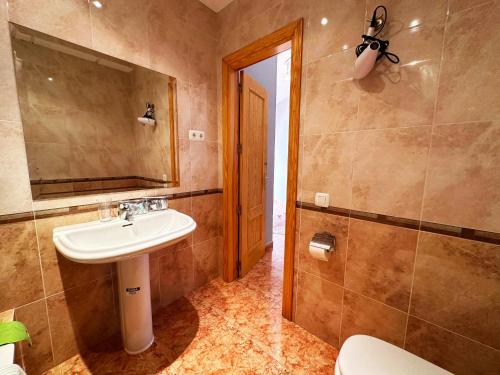 une salle de bain avec un lavabo et un miroir et des toilettes dans l'établissement BAJBAJ - Apartamento 2 dormitorios a 100 metros de la Playa del Bajondillo, a 300 metros del centro de Torremolinos, à Torremolinos