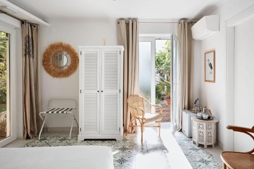 a room with a white cabinet and a chair at Casa Apollo Guesthouse in Faro