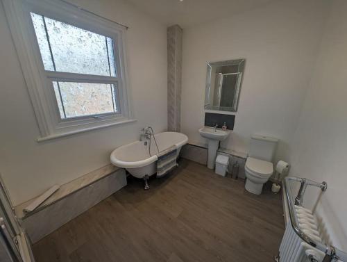 ein Badezimmer mit einer Badewanne, einem WC und einem Waschbecken in der Unterkunft Seaview House - Flat 3 in Lowestoft