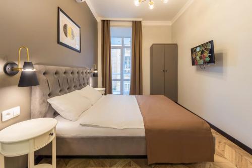 a bedroom with a large bed with a table and a desk at Apartments on Antonovycha in Kyiv