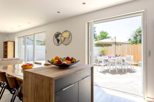une cuisine avec une table avec un bol de fruits dessus dans l'établissement Chez Julien - Superbe maison rénovée avec piscine chauffée, à La Grande Motte