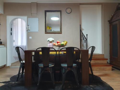 Apartment with Terrace Nona Pavla في تولمين: طاولة عليها كراسي و صحن فاكهة